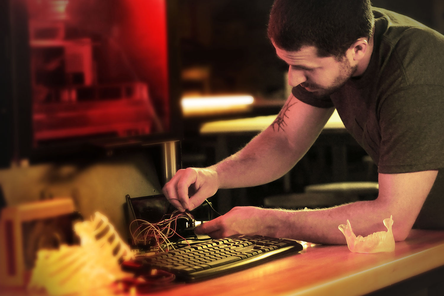 A student looks closely at a 3D printer in a makerspace